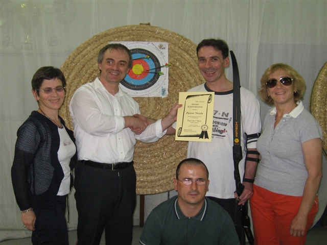 consegna del diploma a Nicola Pavese, con Francesco Cusati e gli arcieri agonisti, tutti in posa davanti alle belle frecce di Nicola